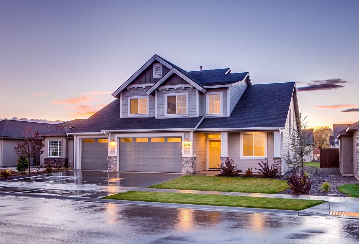 A blue and gray concrete house with an attic gable, photographed at twilight.